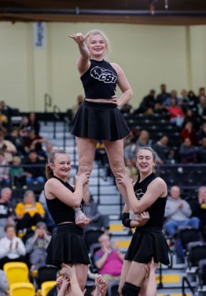 CSI cheer team members holding up another member my her legs 