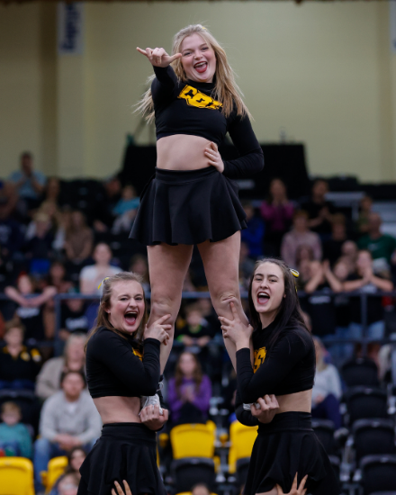 CSI cheer team members holding up another member my her legs